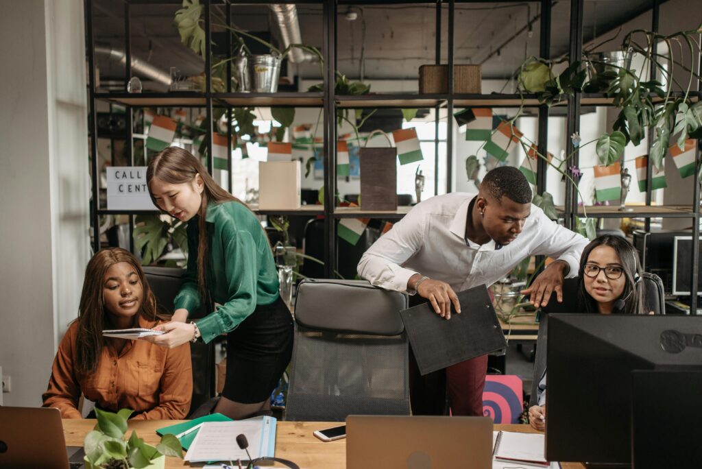 A diverse group of co-workers engaged in communication and teamwork in a call center environment.